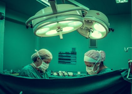 pexels-photo-1250655-1250655 Surgeons in an operating room conducting a medical procedure under bright surgical lights.